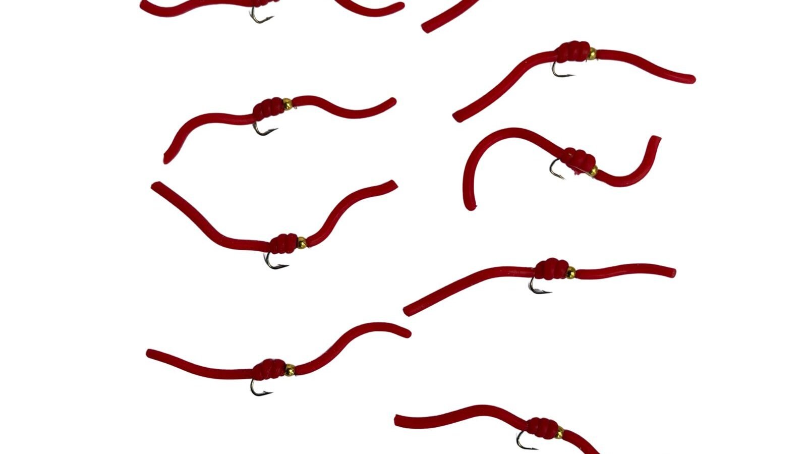 Hand-tied red Squirmy Worm flies laid out on a white background